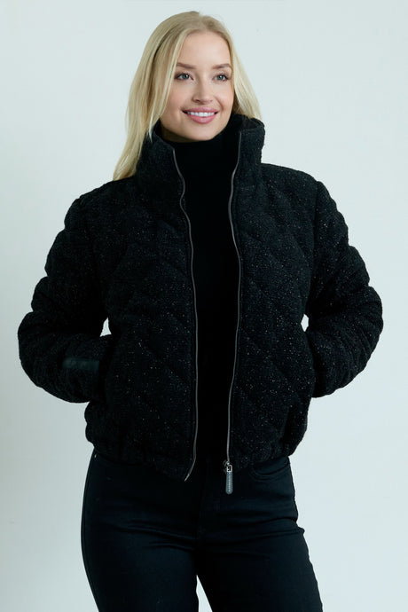 Woman wearing a black jacket on a plain background