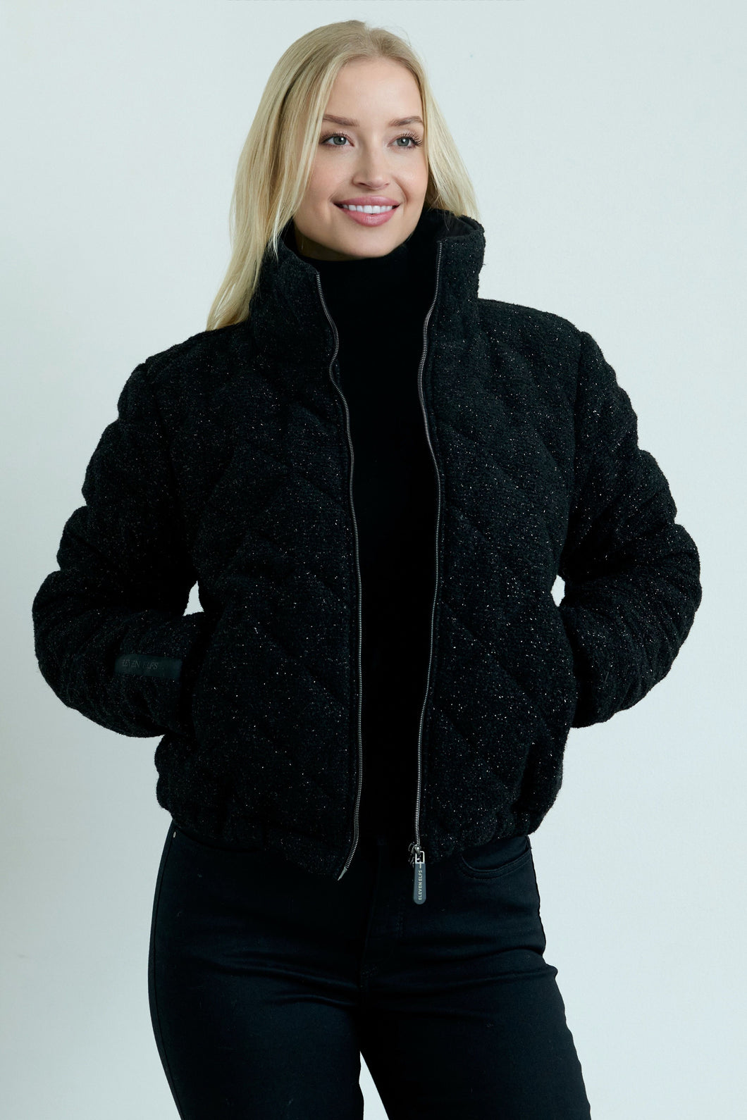 Woman wearing a black jacket on a plain background